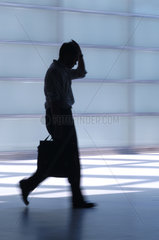 Silhouette eines gruebelnden Mannes mit Aktentasche