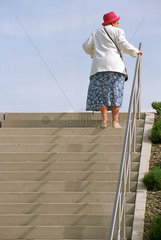 Potsdam  Deutschland  aeltere Frau erklimmt eine Treppe