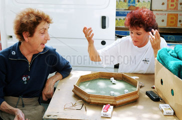 Wien  Oesterreich  zwei Marktfrauen beim Wuerfelspiel