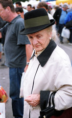 Wien  Oesterreich  Aeltere Dame mit Hut auf einem Flohmarkt