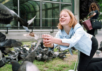 Wien  Oesterreich  ein Maedchen versucht eine Taube zu fangen