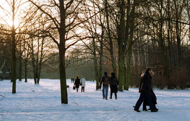 Berlin  Deutschland  Spaziergaenger im schneebedeckten Tiergarten