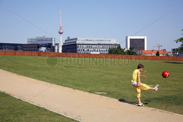 Berlin  Kind kickt Ball im Spreebogenpark