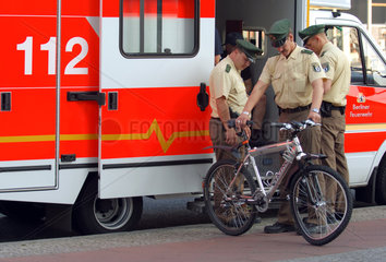 Fahrradunfall: Polizisten stehen am Rettungswagen