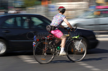 Fahrradfahrer und Auto im Stadtverkehr
