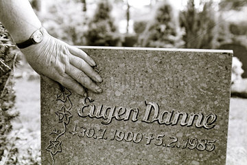 Berlin  Deutschland  eine Frau legt ihre Hand auf den Grabstein ihres Mannes