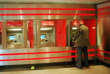 Mann steht am Geldautomat der Berliner Sparkasse