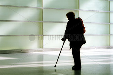 Silhouette einer gehbehinderten Frau mit Stock