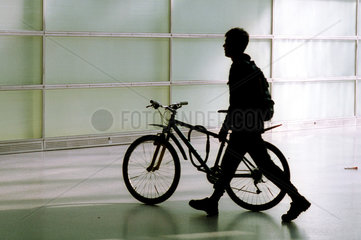 Silhouette eines jungen Mannes mit einem Fahrrad