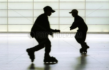 Silhouetten von zwei Jungen auf Inline-Skates