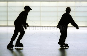 Silhouetten von zwei Jungen auf Inline-Skates