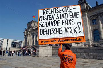 Mann mit Plakat vor dem Reichstag in Berlin