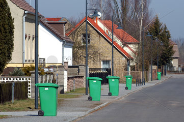 Gruene Tonnen an einer Dorfstrasse in Brandenburg
