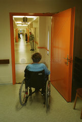 Seniorenheim: Eine Seniorin im Rollstuhl steht im Flur