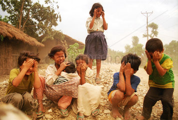 Monsun: Kinder halten sich Haende vor die Augen in Nepal