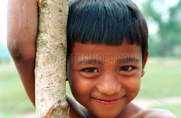 Junge mit Baumstamm in Nepal