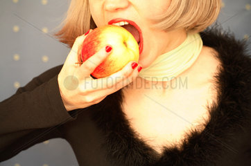 Mund einer Frau beisst in einen Apfel