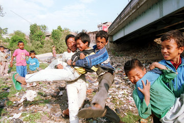 Jungen toben sich auf einer Muellhalde in Nepal aus