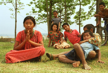 Kinder und Jugenliche sitzen auf einer Wiese in Nepal
