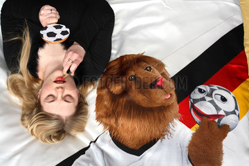 Junge Frau mit WM Maskottchen Goleo auf der Bettwaesche