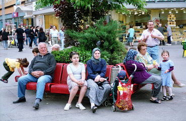 Wien  Oesterreich  Leute unterschiedlicher Herkunft sitzen auf einer Bank