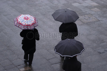 Spaziergaenger mit Regenschirmen