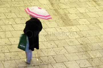 Rentnerin unter einem Regenschirm