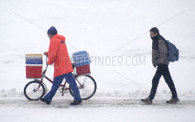 Ein Mann schiebt sein Fahrrad im Schnee