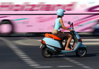 Frau mit Motorroller im Stadtverkehr