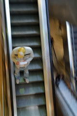 Junger Mann liest Kontoauszug auf der Rolltreppe