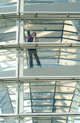 Fensterputzer wischt Fenster im Reichstag in Berlin