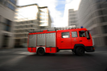 Einsatzwagen der Feuerwehr zwischen Hochhaeusern in Berlin