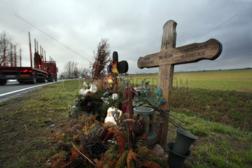 Holzkreuze und Blumen zur Erinnerung an Unfallopfer