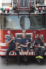 Chicago  USA  Feuerwehrmaenner sitzen auf der Stossstange ihres Feuerwehrautos