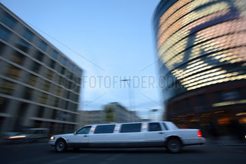 Limousine faehrt vor Hochhaeusern in Berlin