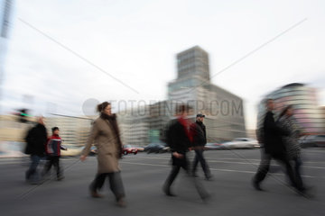 Menschen ueberqueren eine Kreuzung in Berlin