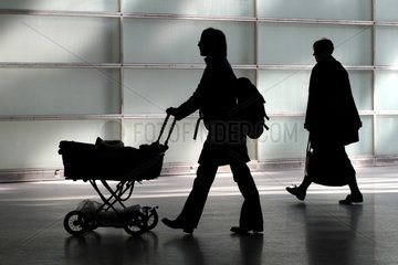Silhouette einer Mutter mit Kinderwagen  eine andere Frau entfernt sich