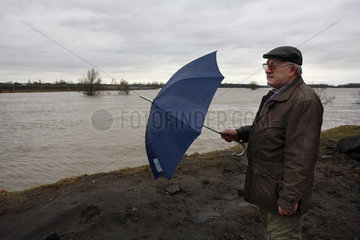 Hochwasser an der Elbe: Anwohner mit Regenschirm auf dem Deich