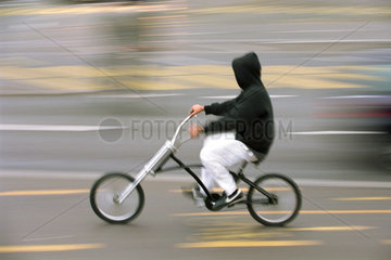 Jugendlicher mit Kapuzenpulli auf dem Fahrrad