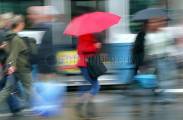 Menschen mit Regenschirmen im Stadtverkehr