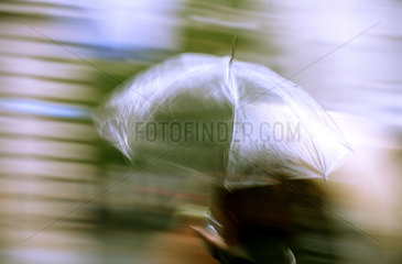 Frau unter transparentem Regenschirm