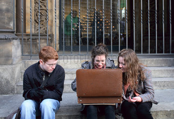 Berlin  Jugendliche sitzen vor einen geoeffnetem Koffer