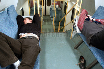 Maenner schlafen in der Regionalbahn
