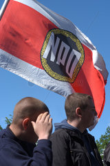 Demonstranten und Fahne mit Logo der NPD in Berlin