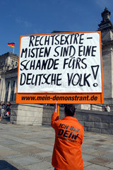 Mann mit Plakat vor dem Reichstag in Berlin