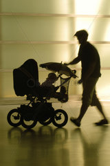 Silhouette eines Vaters mit Kinderwagen