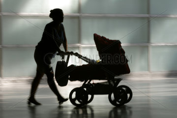 Silhouette einer Frau mit Kinderwagen
