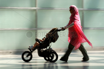 Mutter mit Kopftuch und Kinderwagen