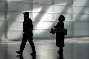 Silhouetten einer Frau mit Taschen und einem Mann