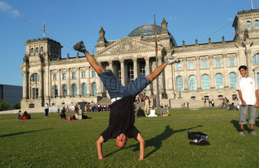 Mann macht Handstand vor dem Reichstag in Berlin